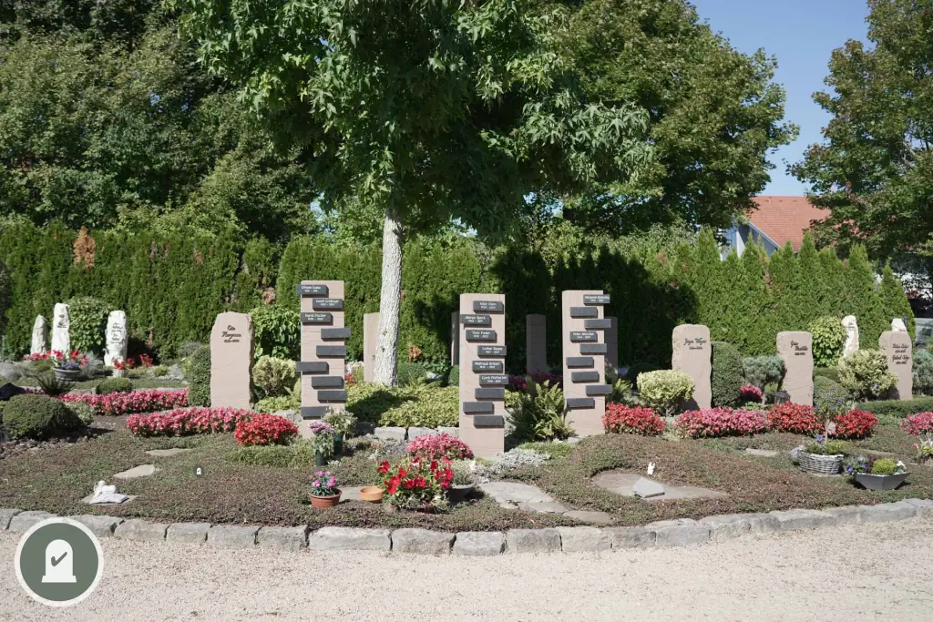 Gemeinschaftsgrabfeld mit hellen Stelen, roten Blumen und Pflasterrand