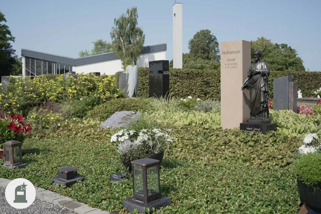 Grabfeld mit Stelen, Bodendeckern und weißen Blüten vor der Friedhofskapelle Hambrücken
