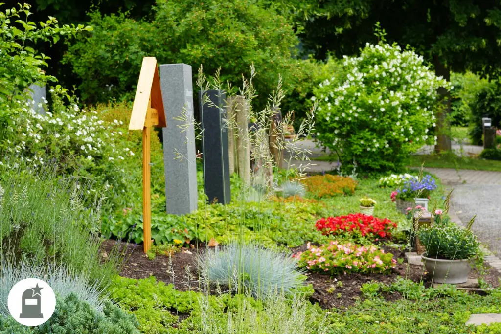 Grabstelen zwischen Gräsern, Stauden und roten Blumen