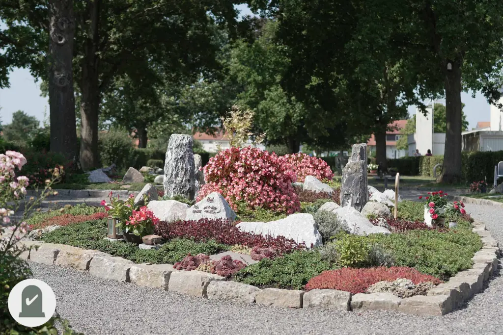 Rundes Gemeinschaftsgrabfeld mit Findlingen und roten Blüten