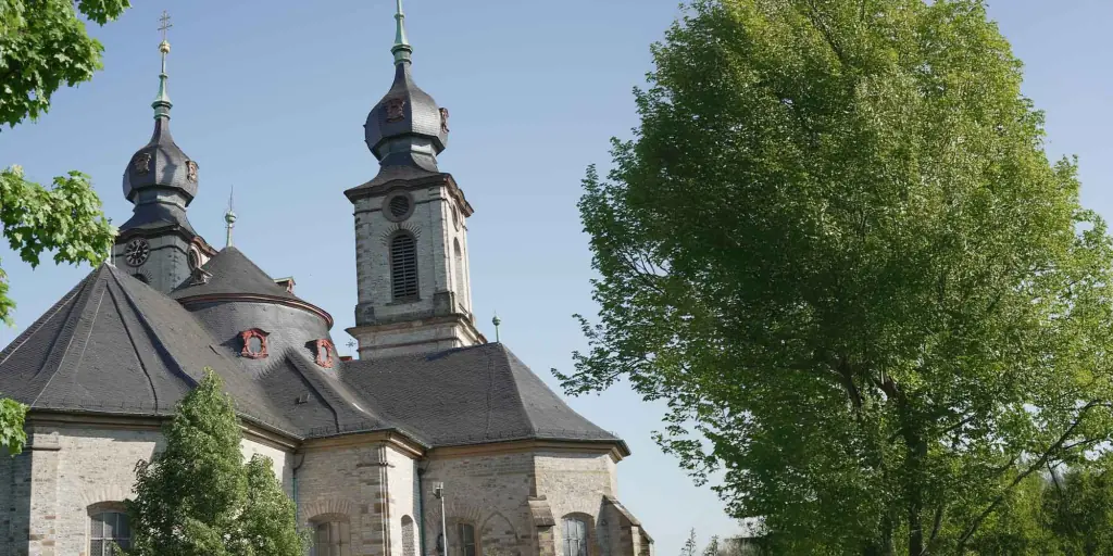 Kirchtürme am Friedhof Bruchsal hinter großen Bäumen