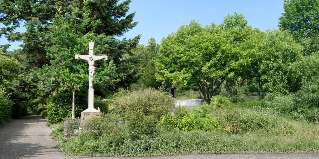 Friedhofskreuz Heidelsheim am Weg zwischen Bäumen