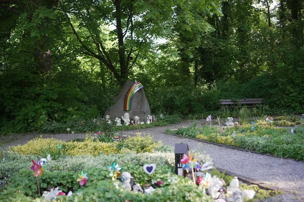 Kleinstkindergrabfeld mit Regenbogen-Gedenkstein, Windrädern und kleinen Gaben