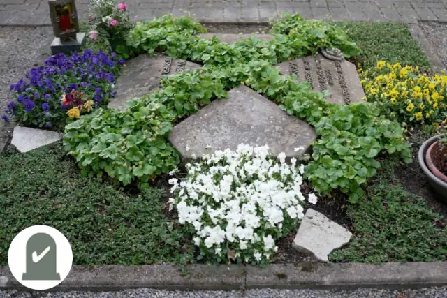 Grabplatte mit weißen und blauen Blüten in Efeurahmen