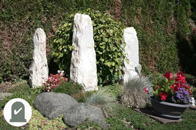 Drei weiße Marmorstelen mit roten Blumen
