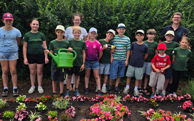 Minigärtner pflanzen Sommerblumen auf dem Friedhof